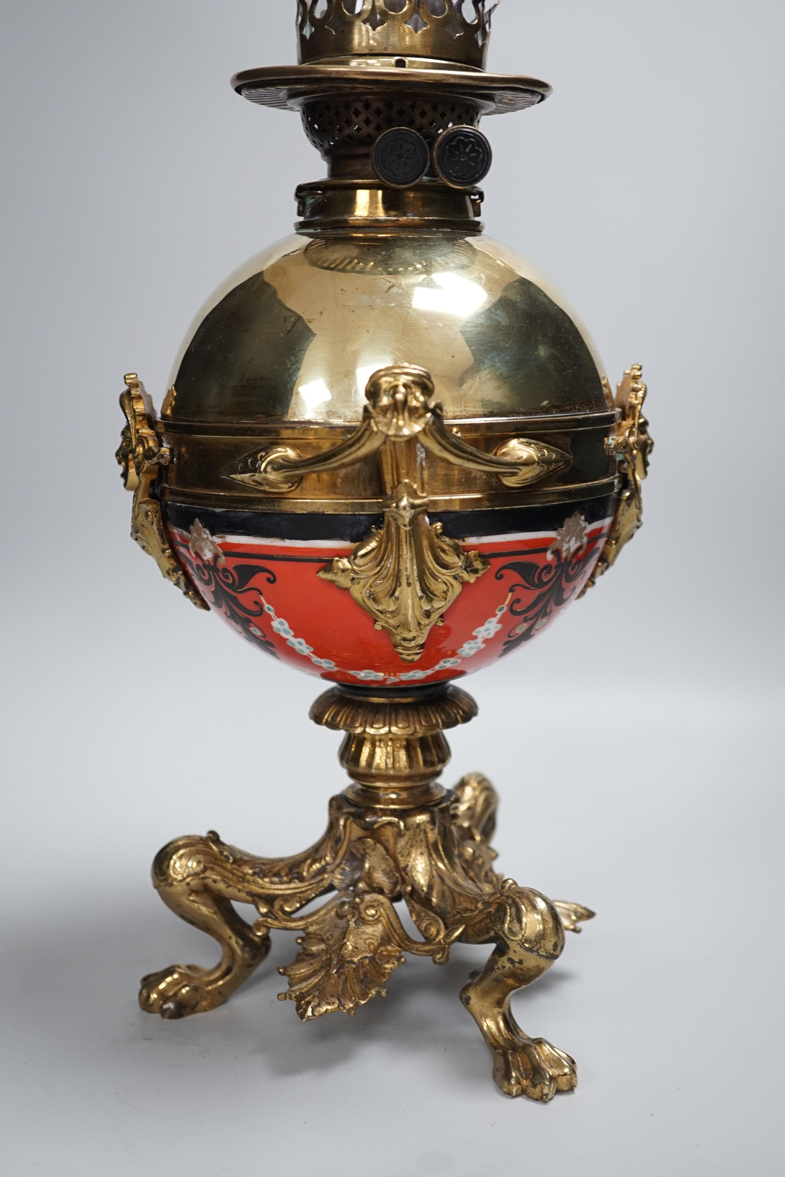 An early 20th century brass and porcelain oil lamp, 60cm total height